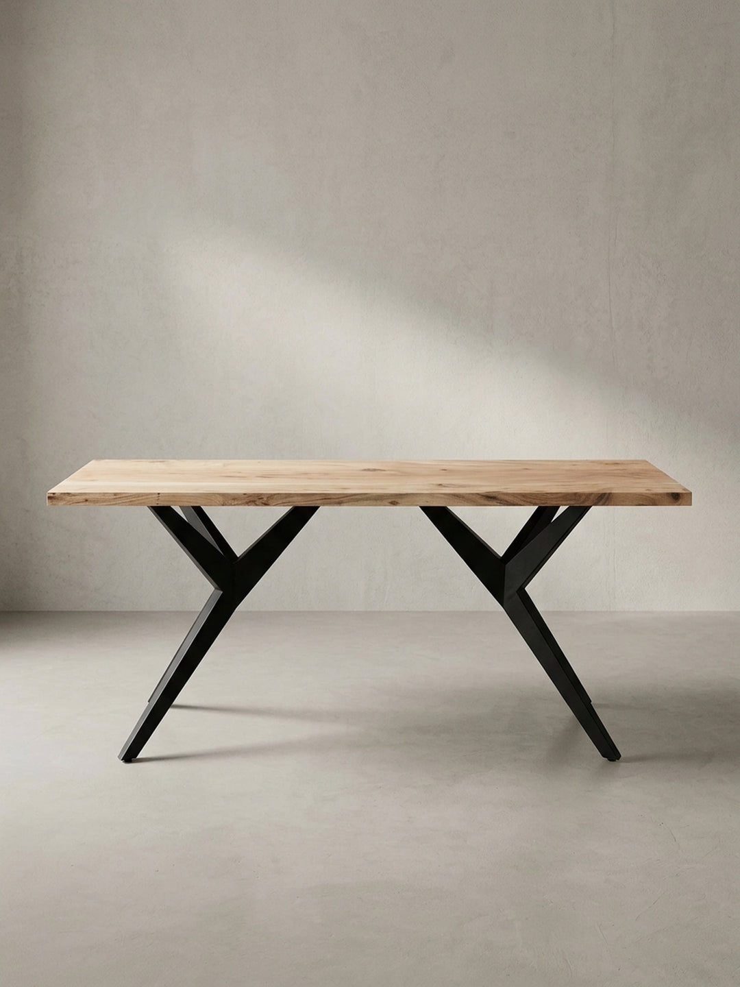 Gesamtüberblick des massiven Esstisches, der die harmonische Balance zwischen der organischen Holzplatte und dem architektonischen Metallfuß darstellt._