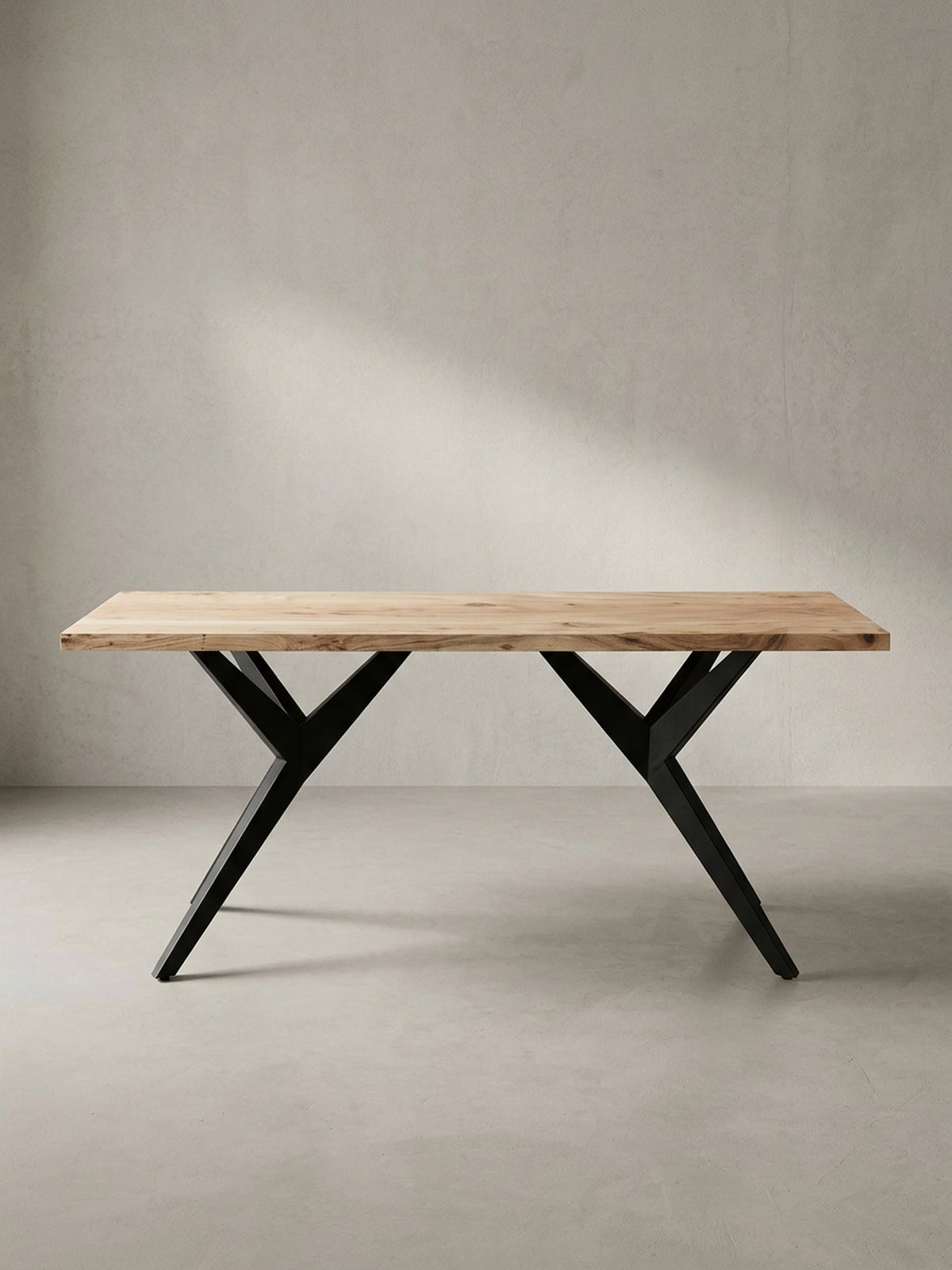 Gesamtüberblick des massiven Esstisches, der die harmonische Balance zwischen der organischen Holzplatte und dem architektonischen Metallfuß darstellt._