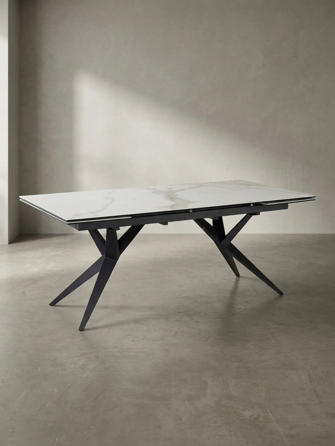 Designer-Esstisch aus Keramik und Metall in einer schrägen 3/4-Ansicht, die die filigrane Tischplatte und das massive Gestell zeigt._