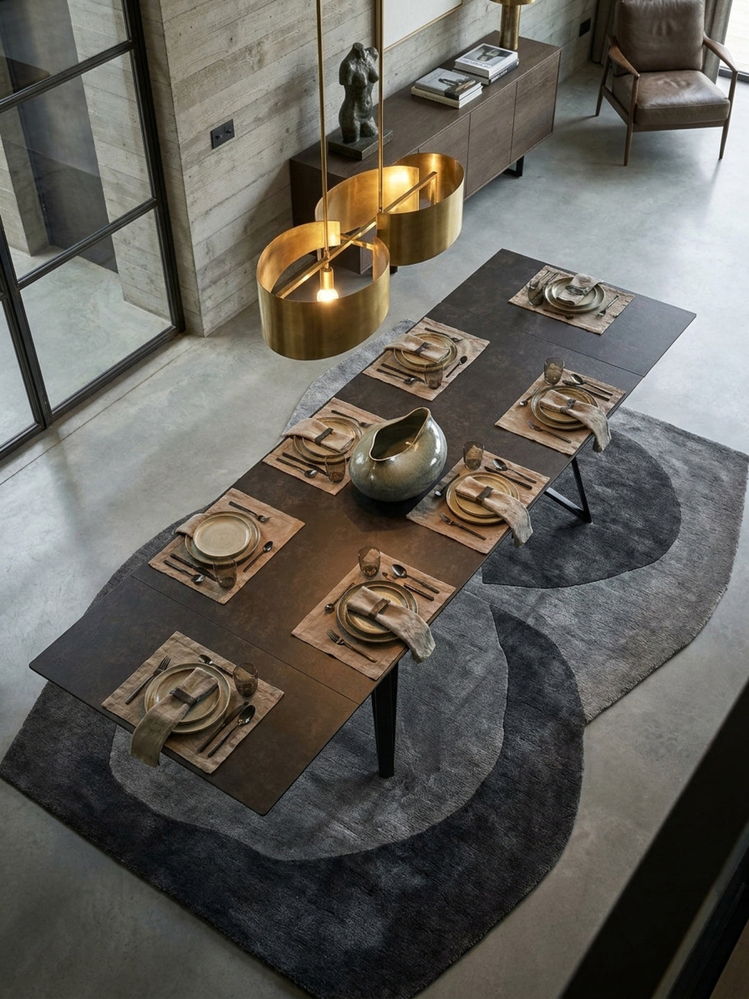 Blick von oben auf den modernen Keramiktisch mit extravagantem Metallgestell, umgeben von vier Stühlen auf einem beigen Teppich in einem lichtdurchfluteten Raum._