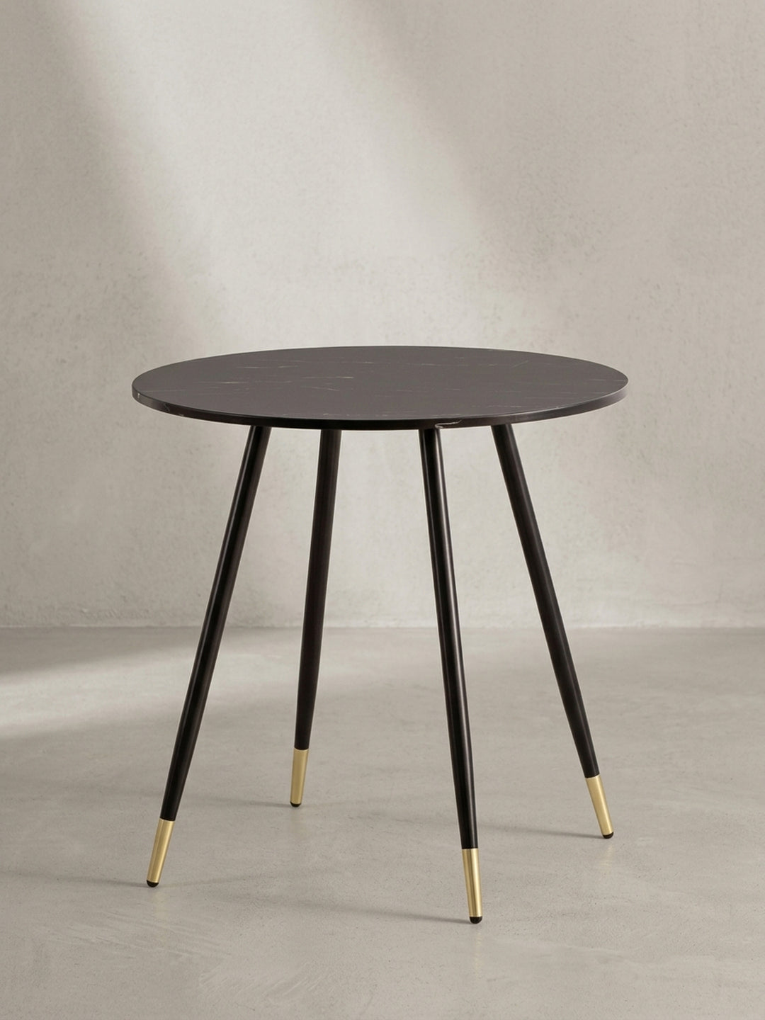 Freigestellter Esszimmertisch 75 cm rund, Frontansicht des Designs mit schwarzen Beinen und goldenen Akzenten auf weißem Hintergrund._