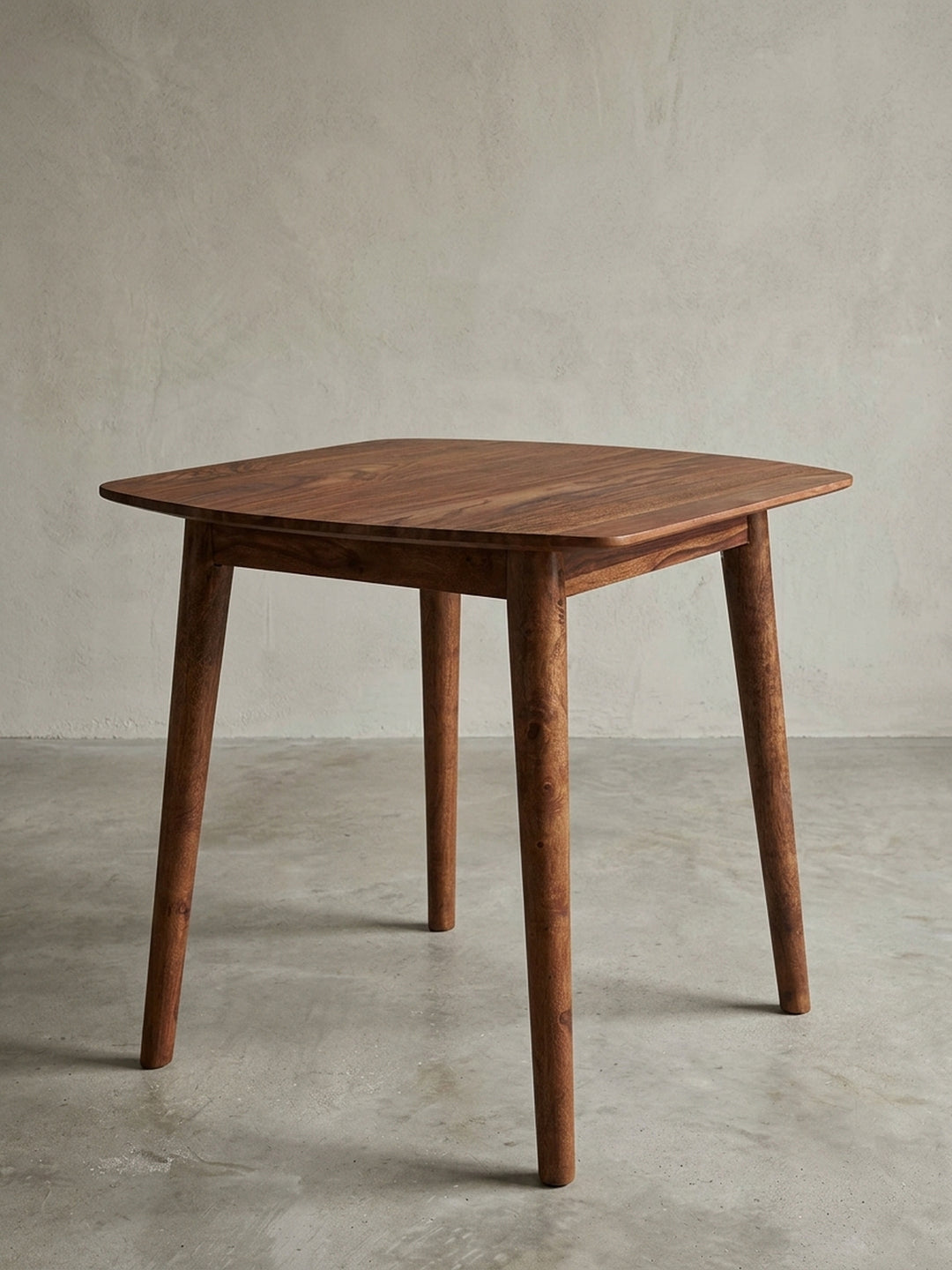 Moderner quadratischer Esszimmertisch aus Massivholz, Frontansicht des 80x80cm großen Sheesham Tisches mit abgerundeten Ecken und konischen Beinen auf weißem Grund._