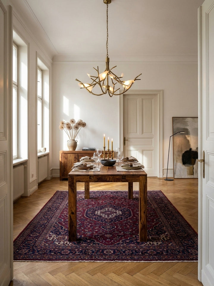 Esszimmertisch aus massivem Sheeshamholz als Mittelpunkt eines eleganten Esszimmers mit Fischgrätparkett und hohen Fenstern, für 6-8 Personen._