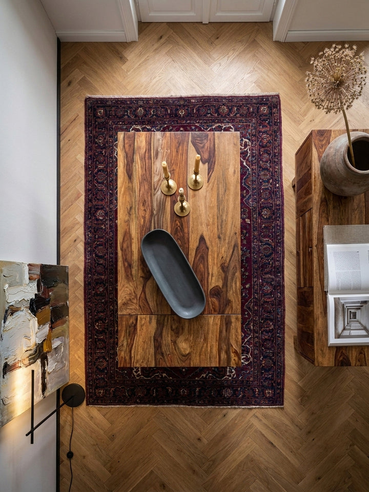 Draufsicht auf den verlängerbaren Sheesham-Holztisch mit sechs Polsterstühlen, arrangiert auf einem orientalischen Teppich im Altbau-Esszimmer._