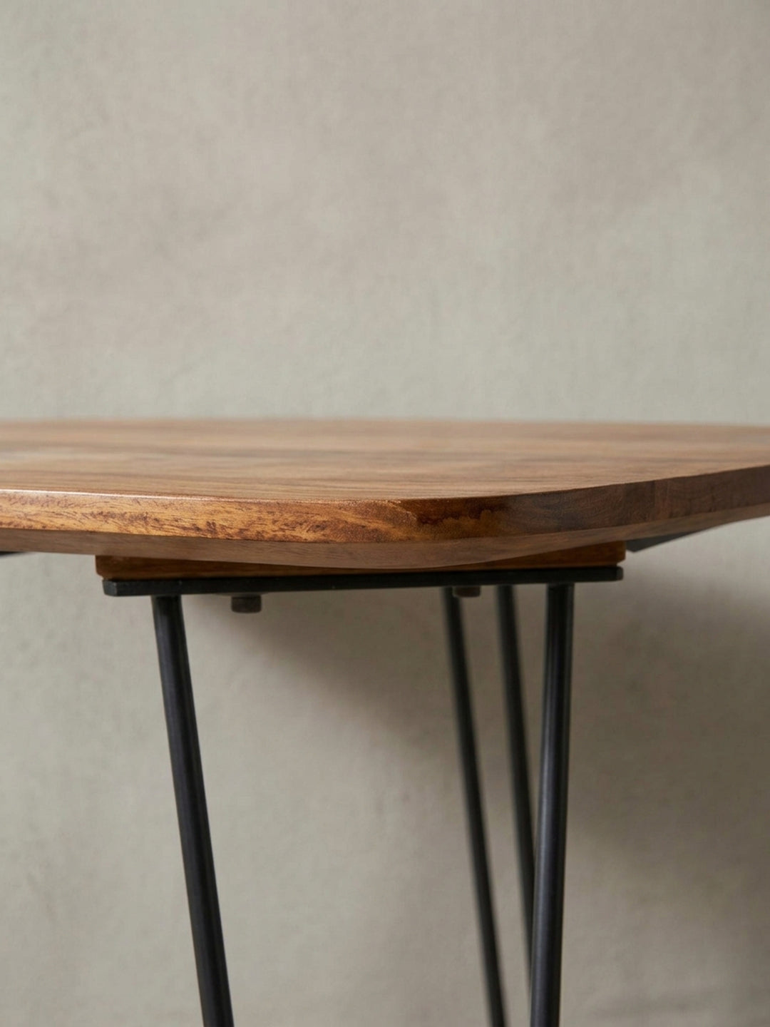 Makro-Detail der Tischkante des Massivholztisches. Die handwerkliche Verarbeitung der abgerundeten Ecken und der Übergang zu den schwarzen Hairpin-Beinen zeigt höchste Qualität._
