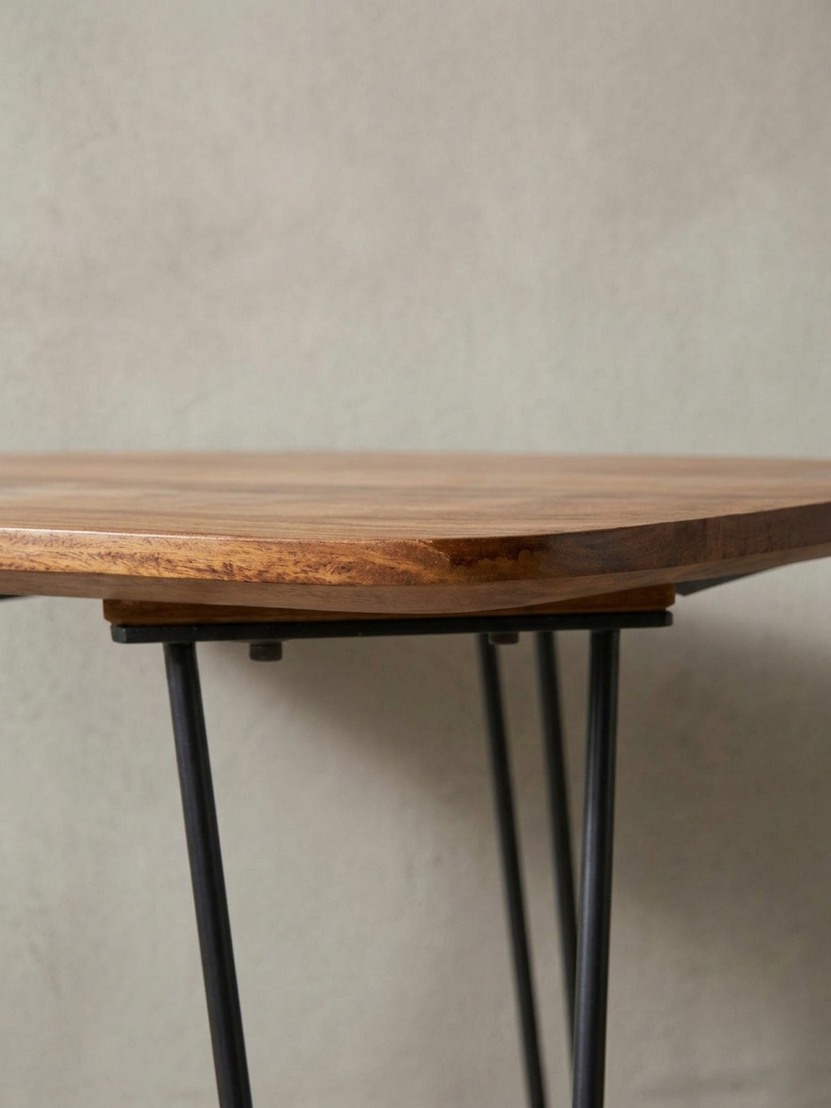 Makro-Detail der Tischkante des Massivholztisches. Die handwerkliche Verarbeitung der abgerundeten Ecken und der Übergang zu den schwarzen Hairpin-Beinen zeigt höchste Qualität.