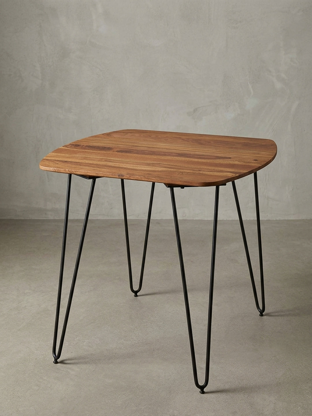 Moderner quadratischer Esstisch mit mattschwarzen Metallbeinen vor weißem Hintergrund. Die 80x80cm große massive Holztischplatte besticht durch ihre abgerundeten, weichen Ecken._