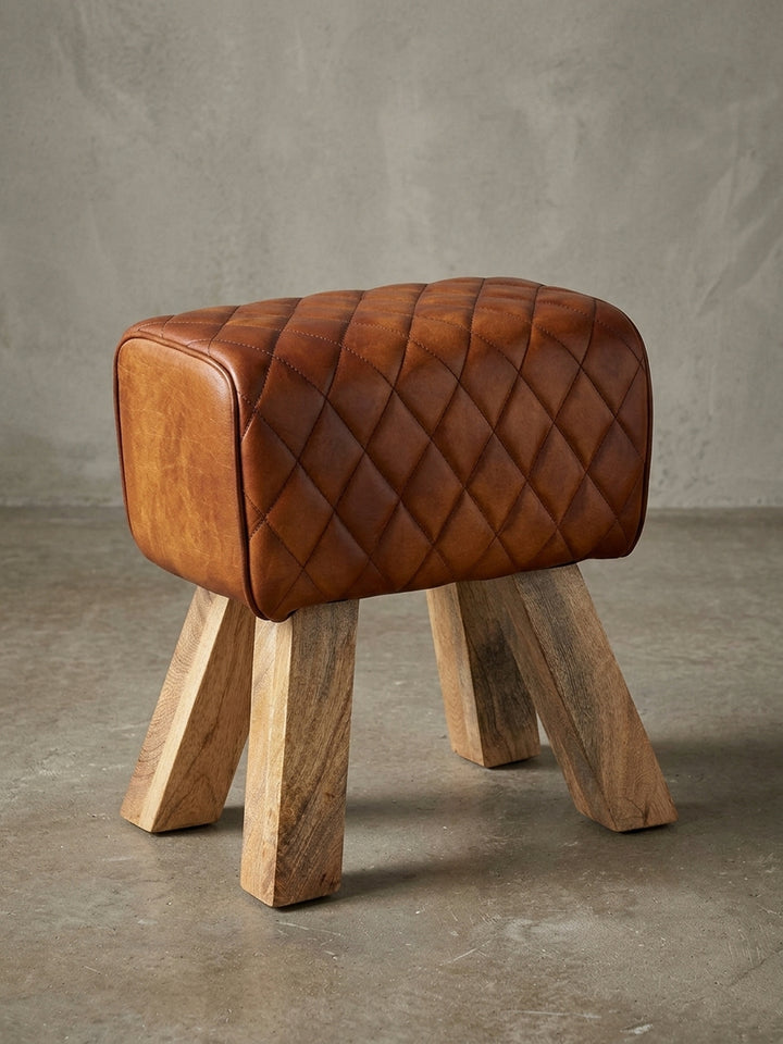 Moderner Sitzhocker mit braunem Echtleder-Bezug und massiven Mangoholz-Beinen, freigestellt in der Frontalansicht, Maße 40x48x27 cm._