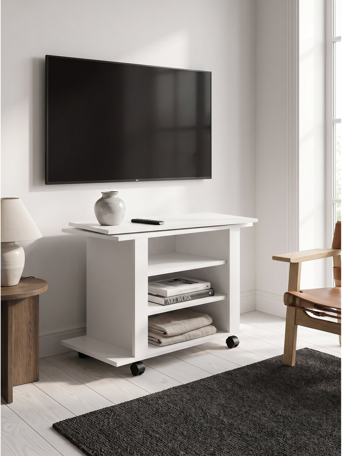 Weißes HiFi Board auf Lenkrollen kombiniert mit einem beigen Leinensofa und einer geriffelten Keramik-Pendelleuchte im Hintergrund.
