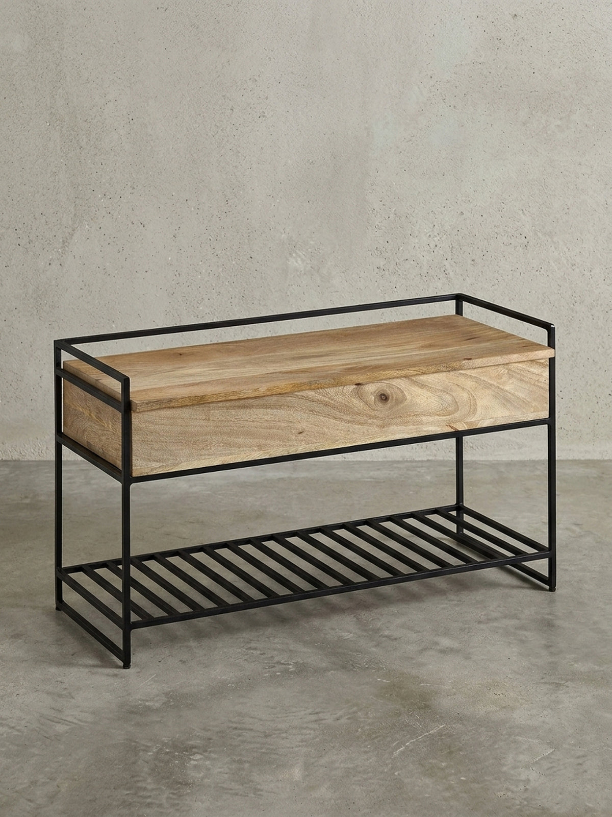 Freigestellte Sitzbank mit Stauraum in 90x52x38 cm, die die Kombination aus massivem Mangoholz und schwarzem Metallgestell zeigt._
