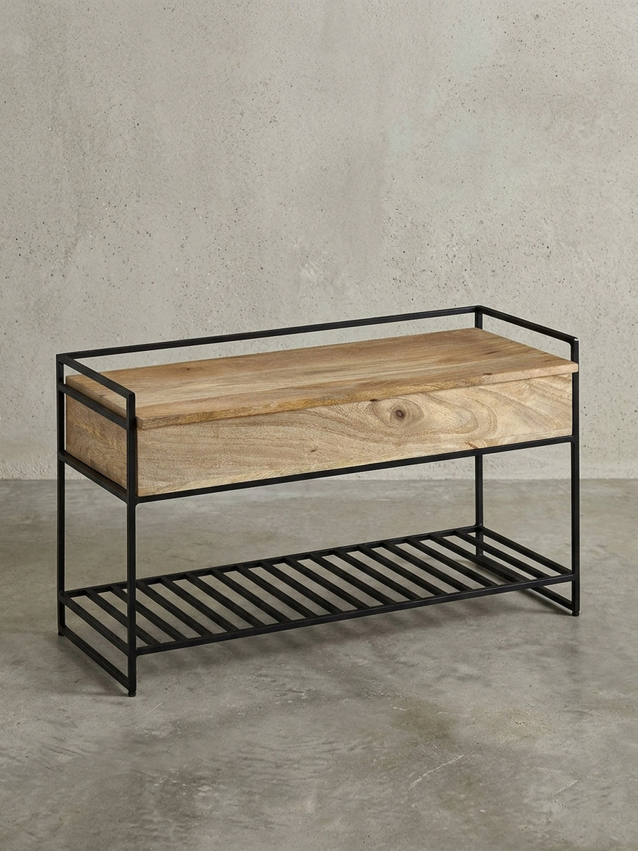 Freigestellte Sitzbank mit Stauraum in 90x52x38 cm, die die Kombination aus massivem Mangoholz und schwarzem Metallgestell zeigt._