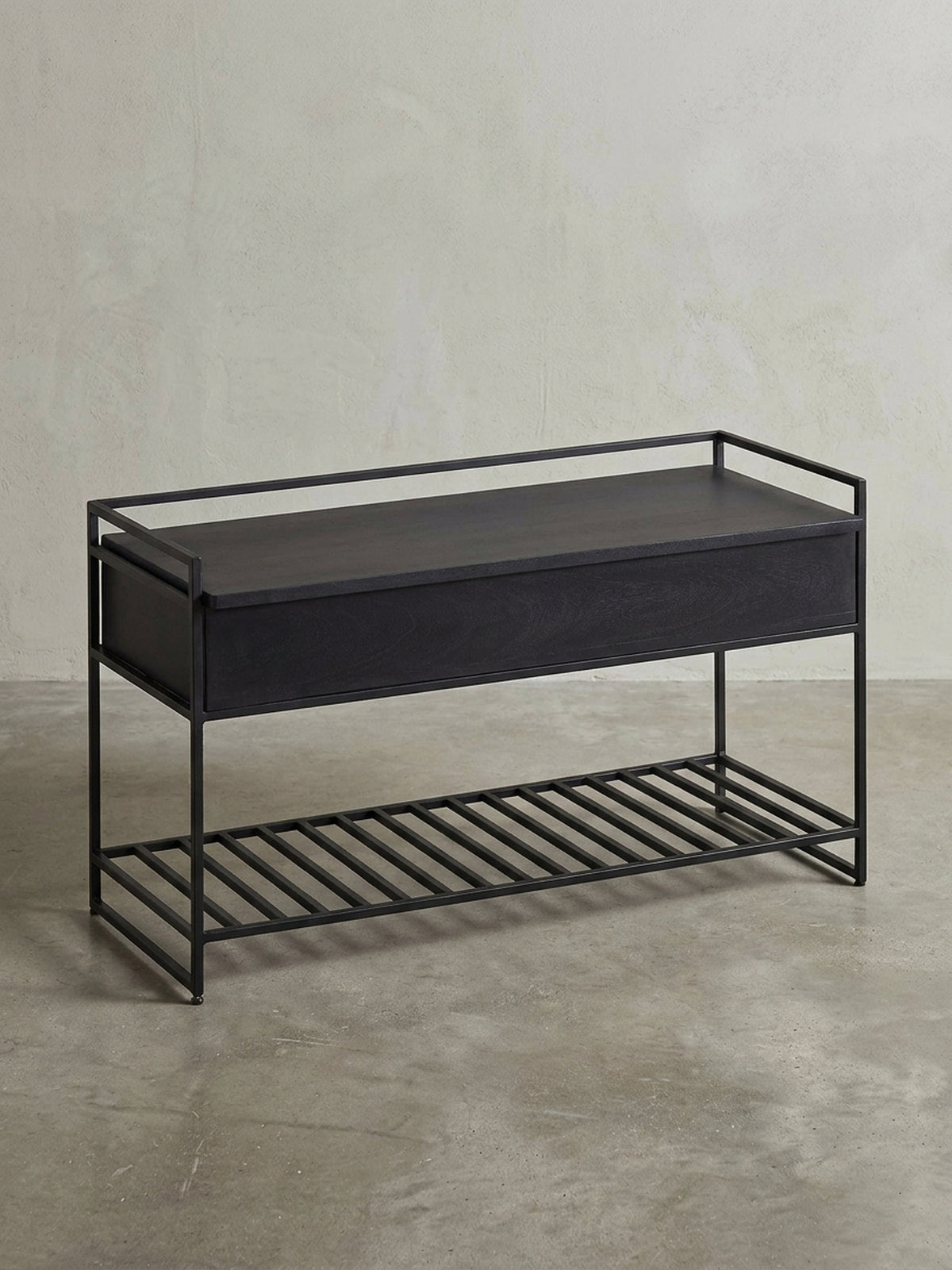Industrielle Flurbank 90 cm breit in schräger 3/4-Ansicht, die die schlanke Metallstruktur und die geräumige Sitzfläche aus schwarzem Massivholz zeigt._