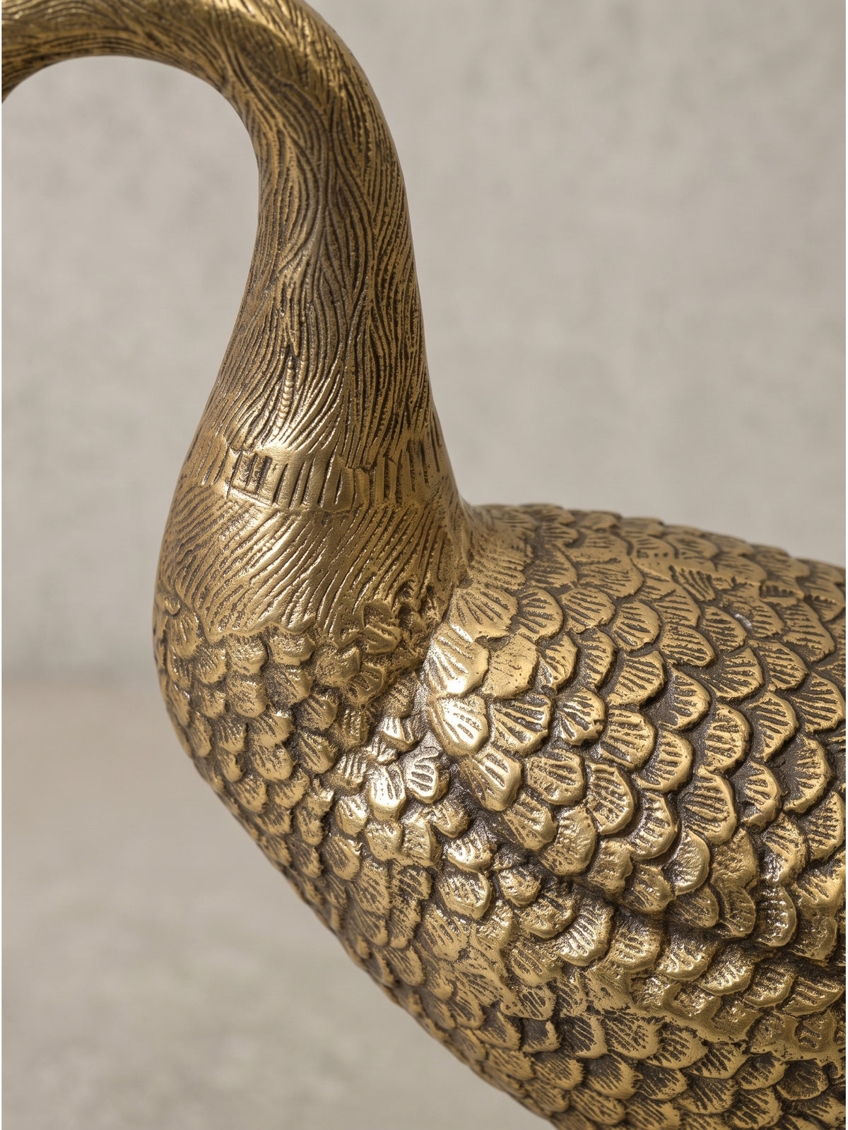 Elegante Tierfigur Gans als modernes Wohnaccessoire aus massivem Aluguss mit goldenem Finish, die feinen, von Hand anmutenden Gravuren des Gefieders fangen das Umgebungslicht stimmungsvoll ein.