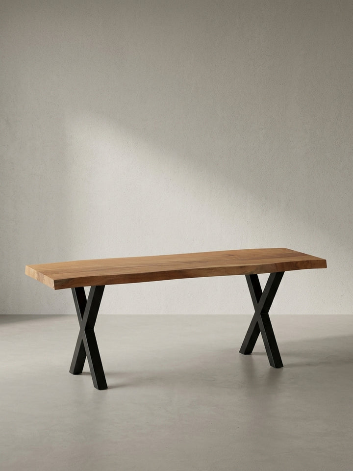 Freigestellte Frontansicht der Garderobenbank 120 cm aus Akazie Massivholz mit den markanten, schwarzen X-förmigen Metallbeinen auf weißem Hintergrund._