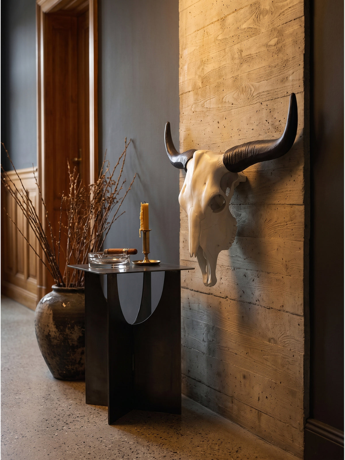 Büffelschädel Wandskulptur aus Metall Weiß Schwarz im Industrial Style über einem Stahl-Konsolentisch mit Kunstbänden