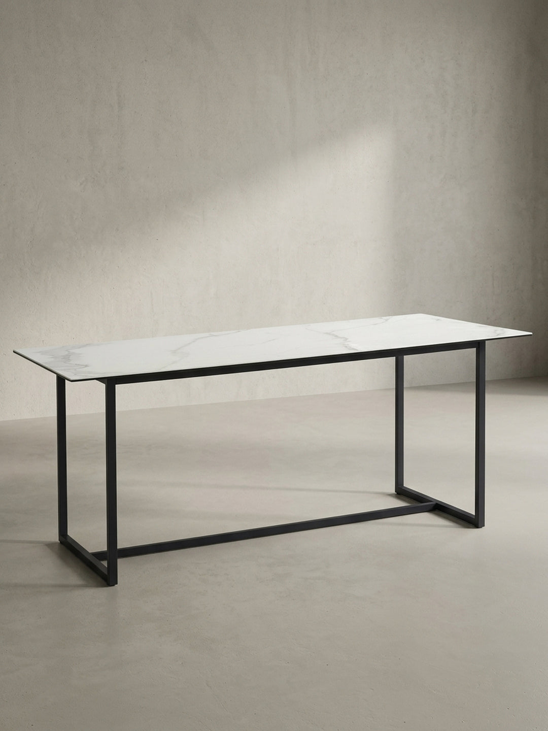 Freigestellter rechteckiger Esstisch 180x90x76 cm mit robuster Keramikplatte in Marmoroptik und mattschwarzen Metallbeinen von vorne links_