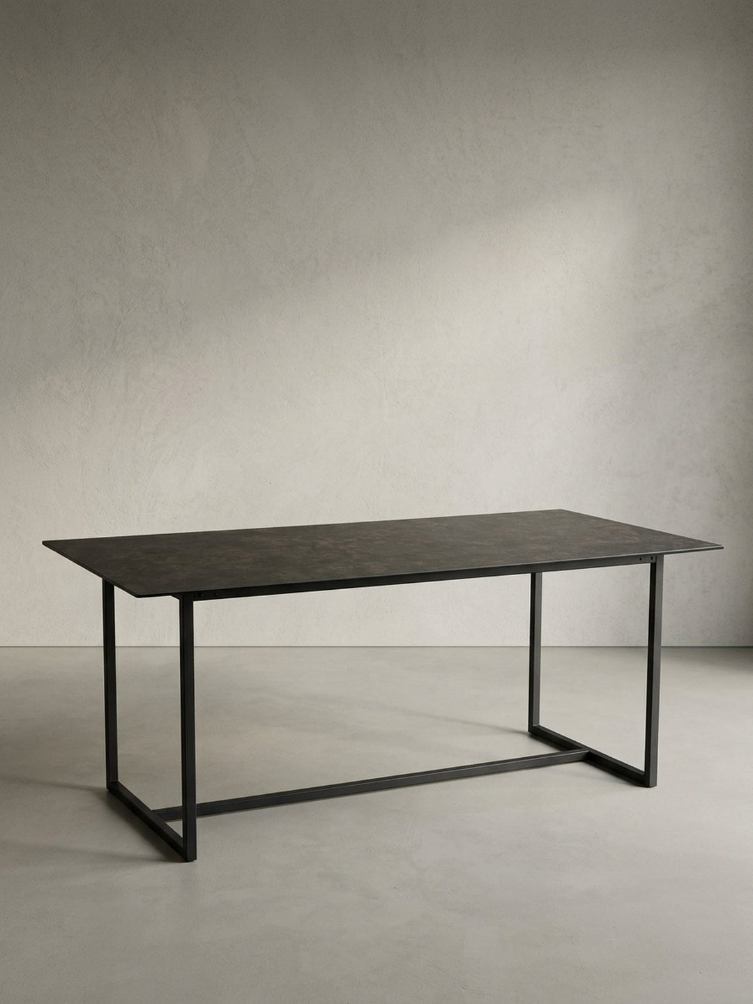 Freigestellter Esstisch 180x90 cm schwarz mit Keramik-Glasplatte und U-förmigem Metallgestell in Schrägansicht_
