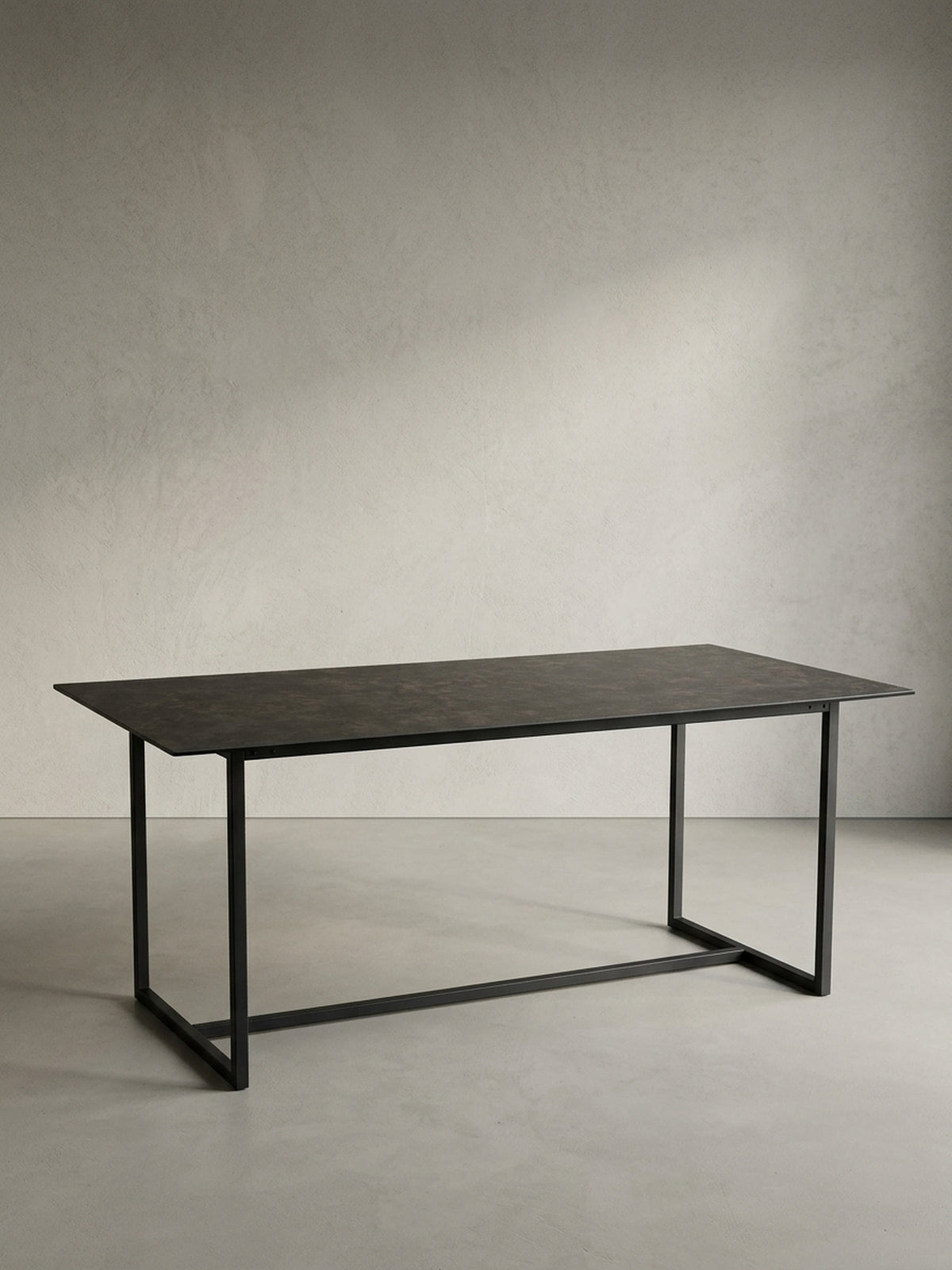Freigestellter Esstisch 180x90 cm schwarz mit Keramik-Glasplatte und U-förmigem Metallgestell in Schrägansicht