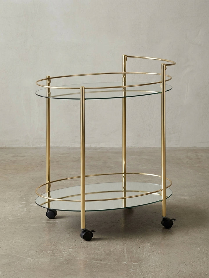 Moderner Servierwagen Gold mit Glasplatten, freigestellt auf weißem Hintergrund, zeigt die komplette Silhouette und die eleganten, geschwungenen Linien._