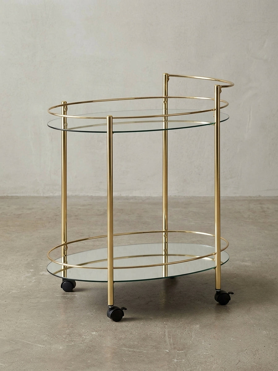 Moderner Servierwagen Gold mit Glasplatten, freigestellt auf weißem Hintergrund, zeigt die komplette Silhouette und die eleganten, geschwungenen Linien._