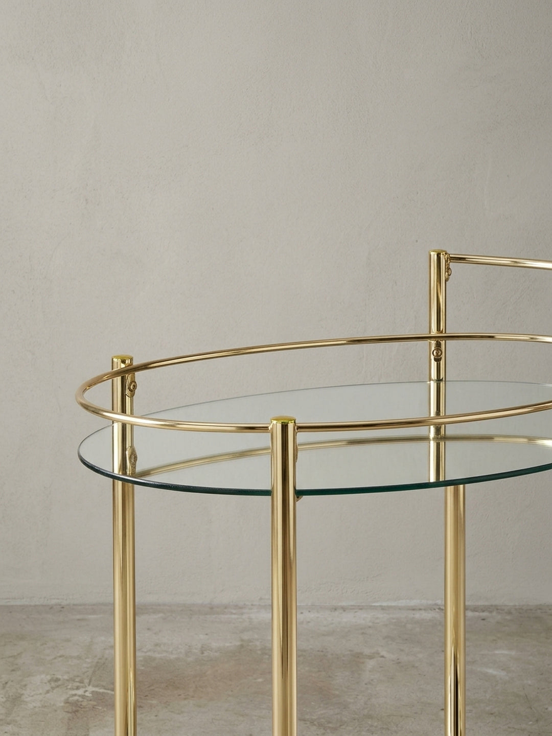 Eleganter goldener Servierwagen mit Spiegelglas auf der unteren Ablage, perfekt als mobile Minibar für Spirituosen und Gläser im Esszimmer oder Wohnzimmer._