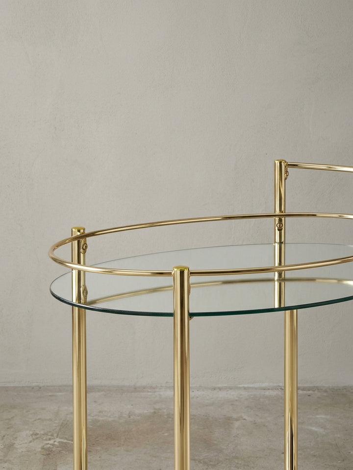 Eleganter goldener Servierwagen mit Spiegelglas auf der unteren Ablage, perfekt als mobile Minibar für Spirituosen und Gläser im Esszimmer oder Wohnzimmer._