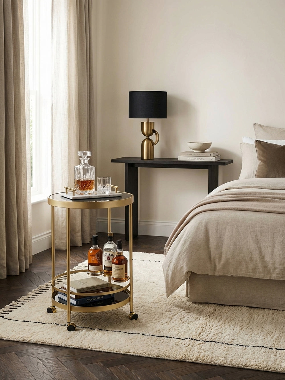 Eleganter Servierwagen in Gold und Schwarz, stilvoll in einem Altbau-Wohnzimmer mit Stuck und Parkettboden als mobile Minibar arrangiert._