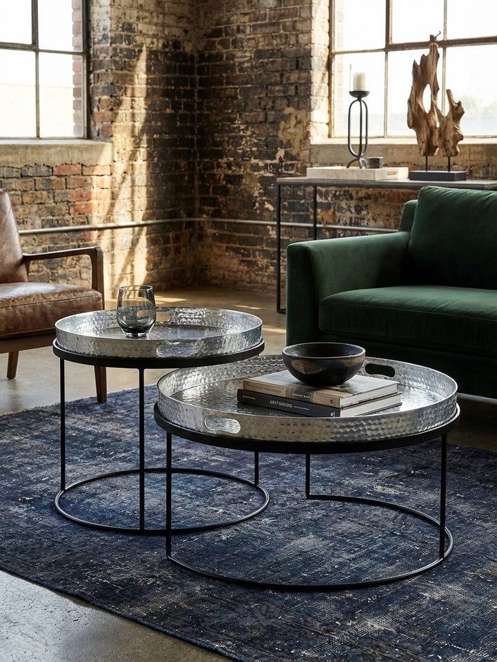 Detailaufnahme der Hammerschlag-Oberfläche eines silbernen Aluminium-Tabletts, die handwerkliche Textur und den Glanz des Metalls betonend._