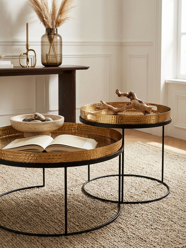 Detailaufnahme der texturierten Hammerschlag-Oberfläche eines goldenen Tabletttischs, die handwerkliche Qualität und das einzigartige Muster des Aluminiums zeigend._