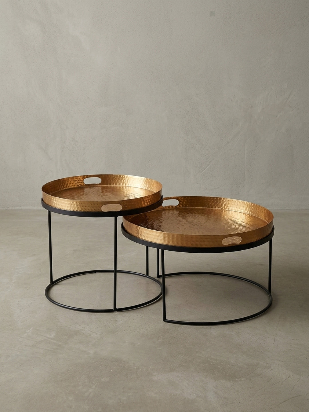 Perspektivische Ansicht des modernen Satztischs, der das Zusammenspiel der beiden runden Tische und den Glanz der gehämmerten Gold-Oberflächen betont._