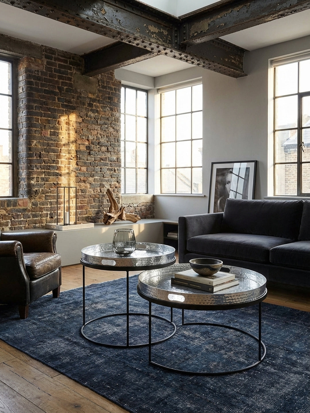 Runder Satztisch in Silber und Schwarz von oben gesehen, zeigt die flexible Anordnung der zwei Tische mit abnehmbarem Tablett im Wohnbereich._