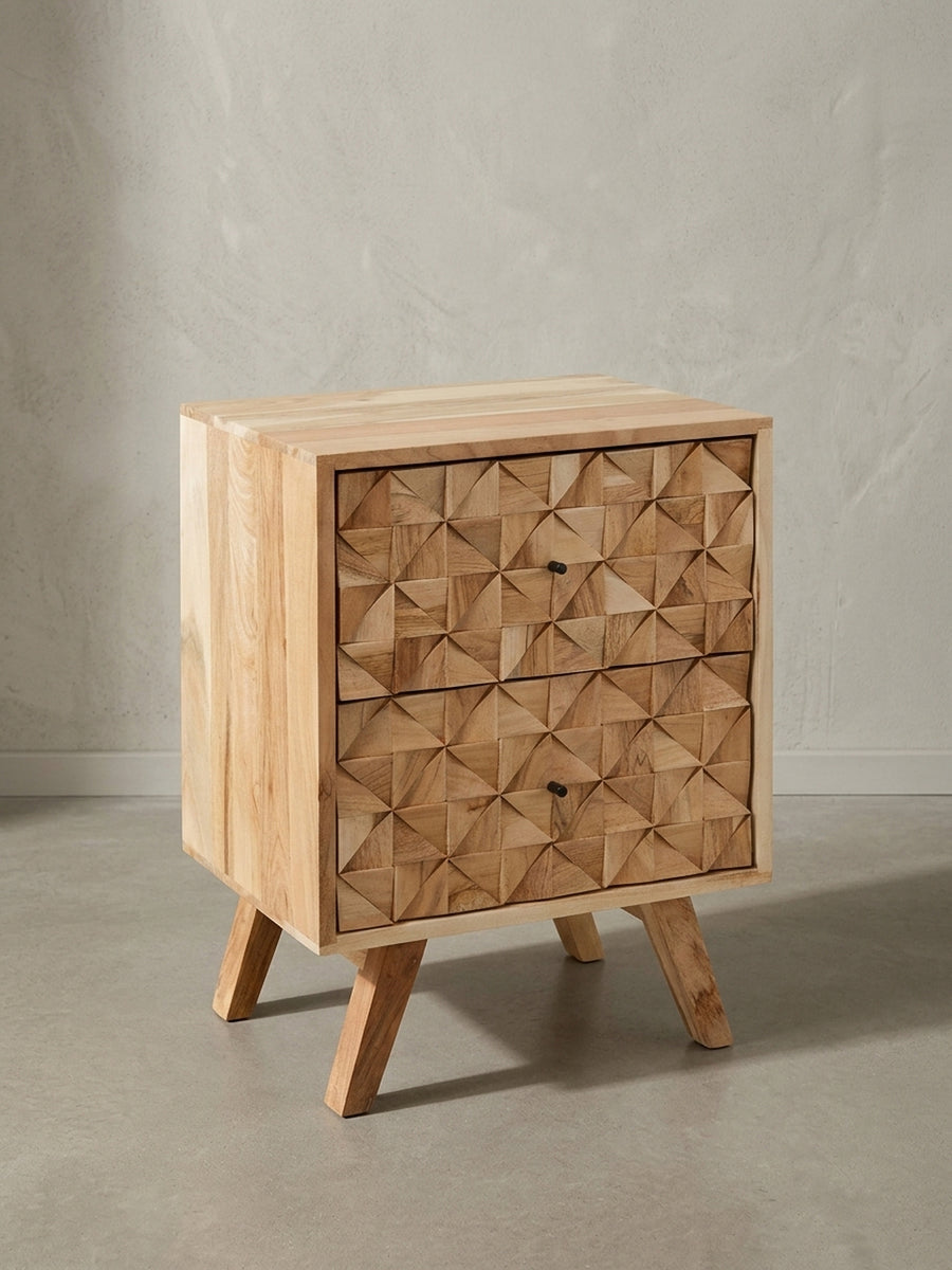 Freigestellter Akazienholz Nachttisch mit zwei Schubladen. Frontale Ansicht der geometrischen 3D-Holzstruktur und der dezenten schwarzen Metallgriffe des 61cm hohen Schlafzimmermöbels._