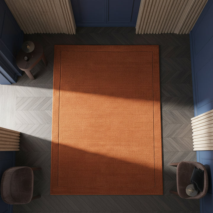 Nahaufnahme eines handgewebten terracottafarbenen Teppichs mit Rippenstruktur in einem luxuriösen Interieur_