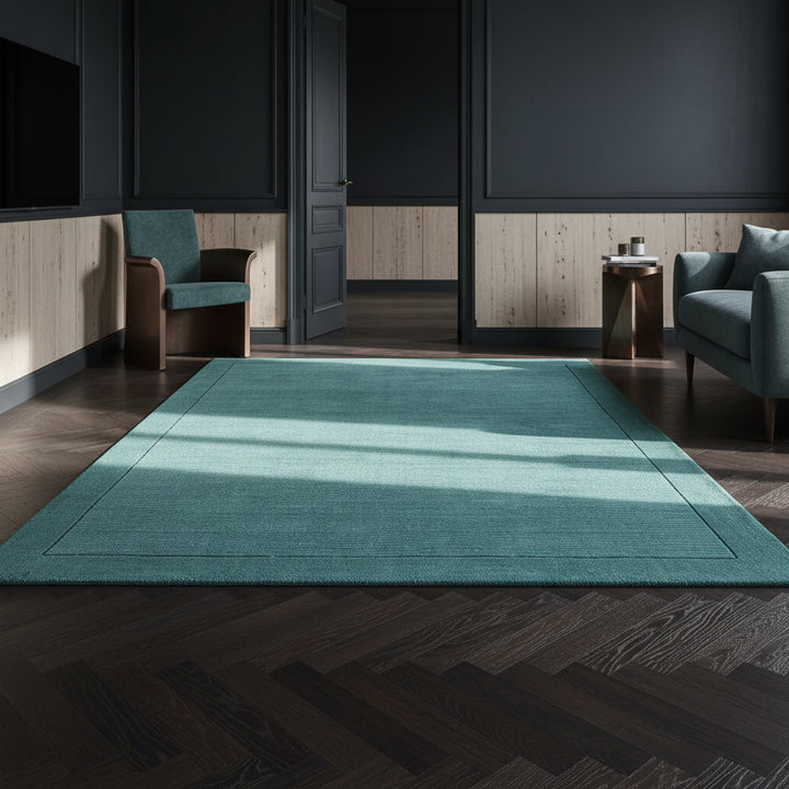 Moderner teal-farbener Teppich auf dunklem Parkett vor einer dunkelblauen Wand_