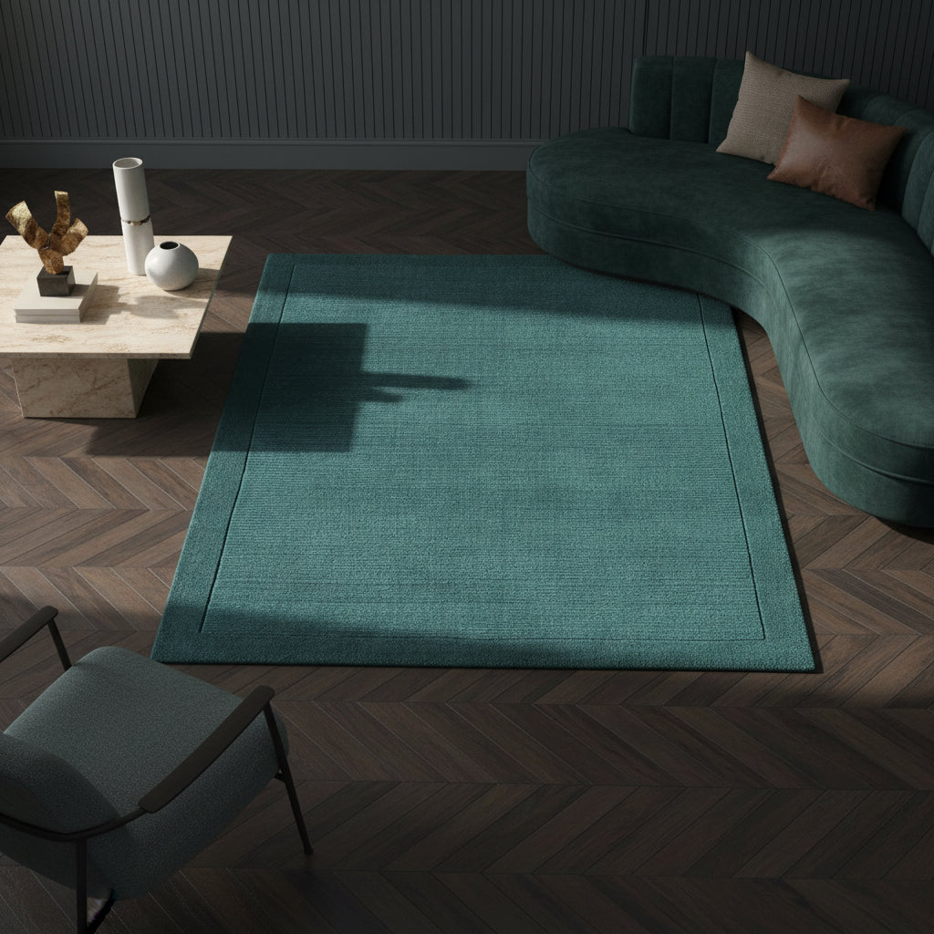 Moderner teal-farbener Teppich auf dunklem Parkett vor einer dunkelblauen Wand_