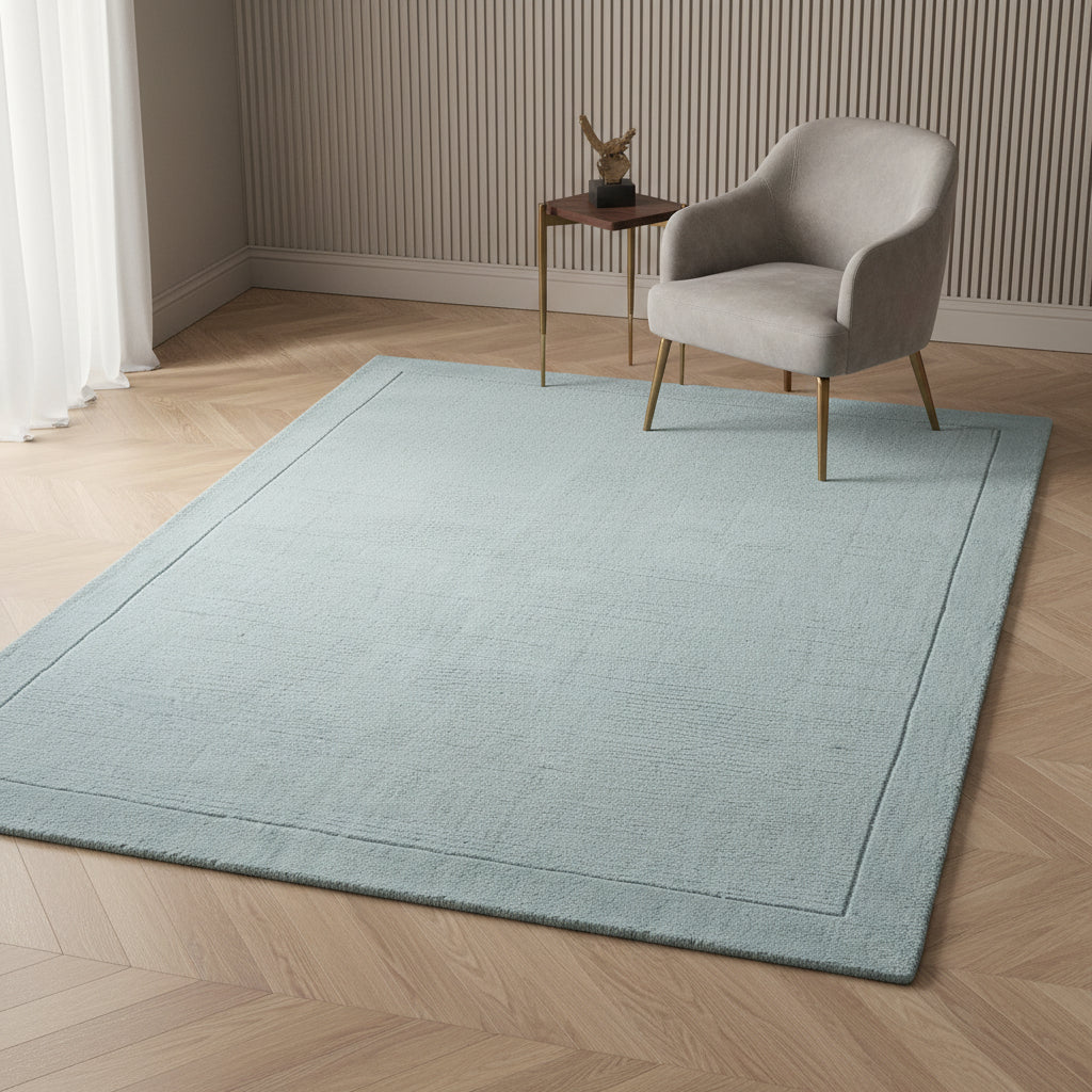 Nahaufnahme eines hellblauen strukturierten Teppichs auf dunklem Holzboden in einem edlen Raum_Kadima Design_