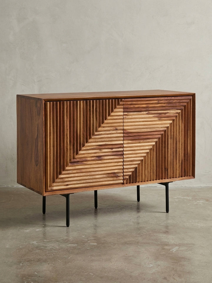 Frontansicht der Anrichte aus Sheesham-Holz, 100 cm breit, mit geometrischer 3D-Front und schwarzen Metallbeinen, freigestellt auf weißem Hintergrund._