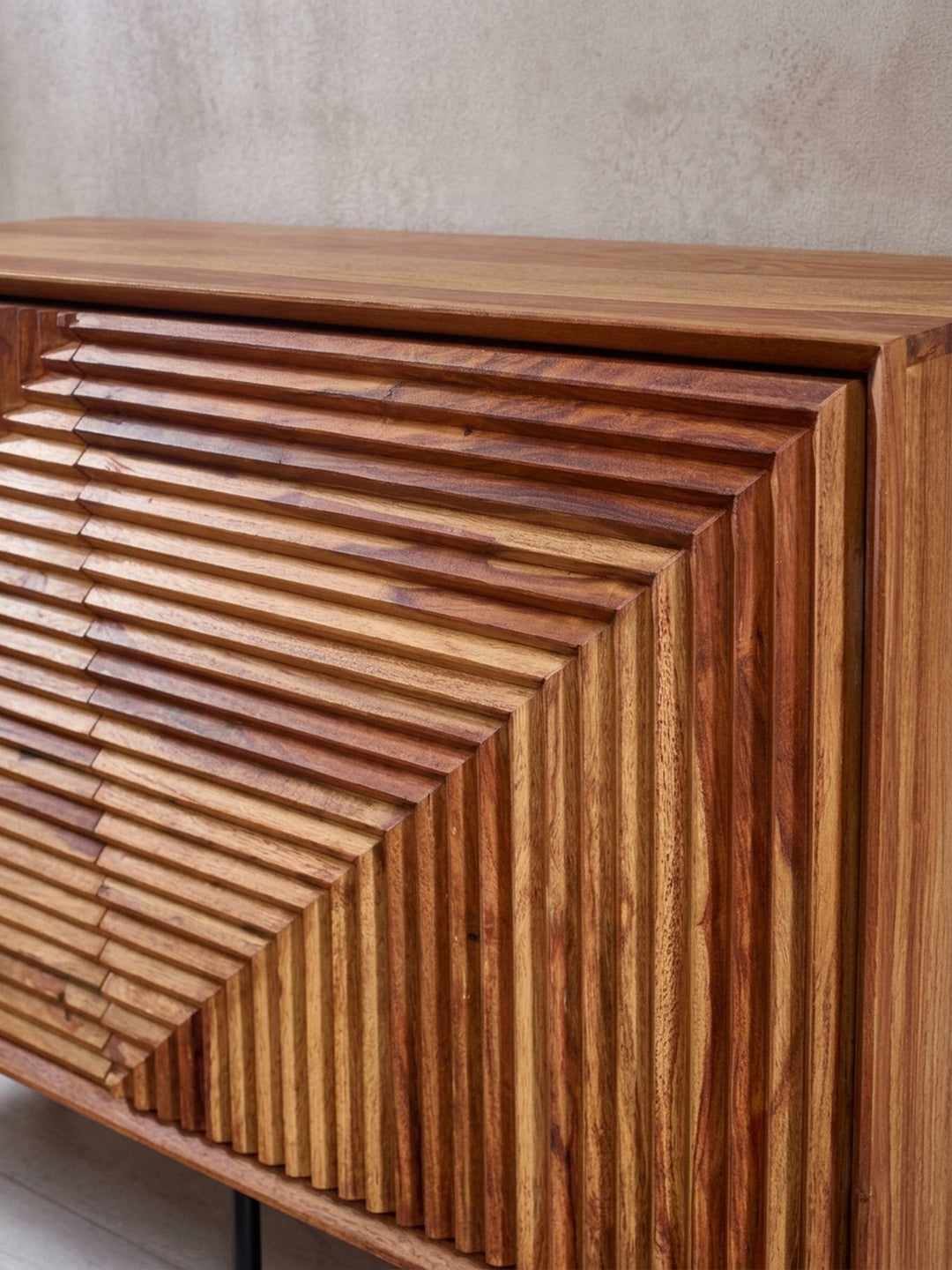 Detailaufnahme der geschnitzten Türfront des Sideboards, die das präzise handgefertigte Muster und die warme Farbe des lackierten Sheesham-Holzes zeigt._