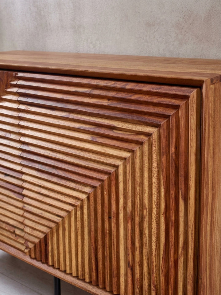Detailaufnahme der geschnitzten Türfront des Sideboards, die das präzise handgefertigte Muster und die warme Farbe des lackierten Sheesham-Holzes zeigt._