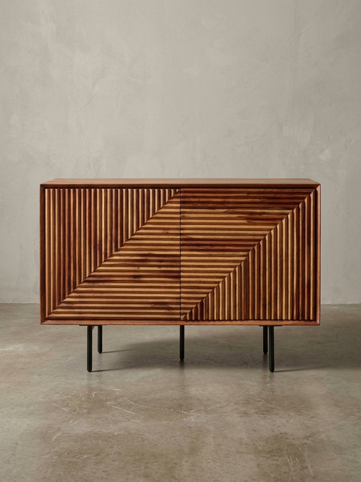 Schräge 3/4-Ansicht des modernen Sideboards, das die Tiefe der 3D-Struktur und die Kombination von massivem Holz mit filigranem Metallgestell betont._