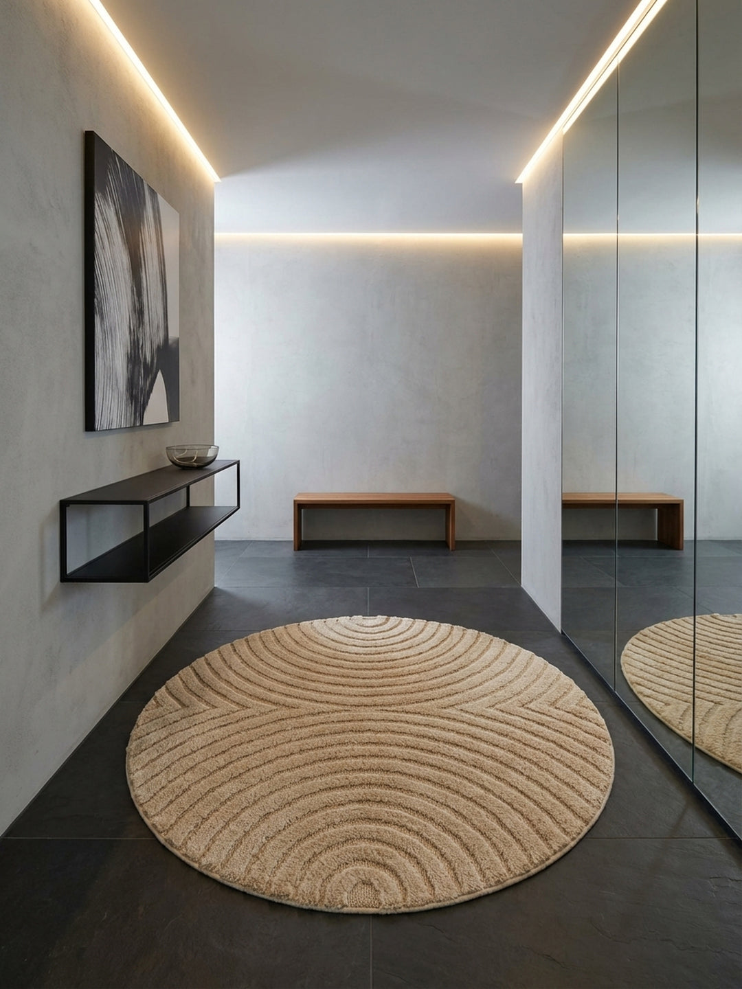 Einladender runder Teppich in Beige mit strukturiertem Muster auf dunklem Schieferboden in einem modern gestalteten, hellen Flur._