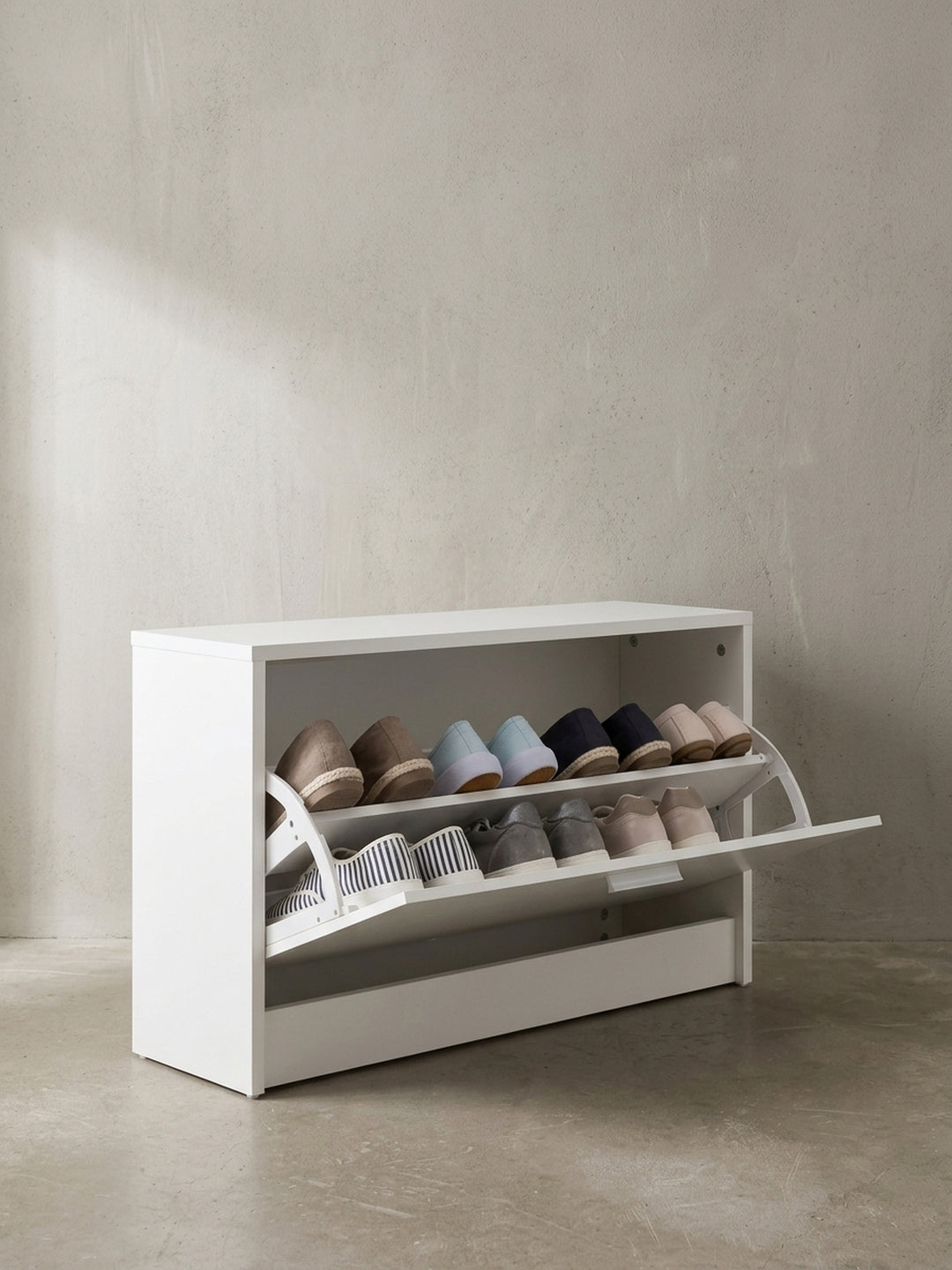 Schmale Schuhbank 80x47x24 cm in Weiß mit zwei Ebenen im großen Kippfach freigestellt vor neutralem Hintergrund von vorne gesehen._
