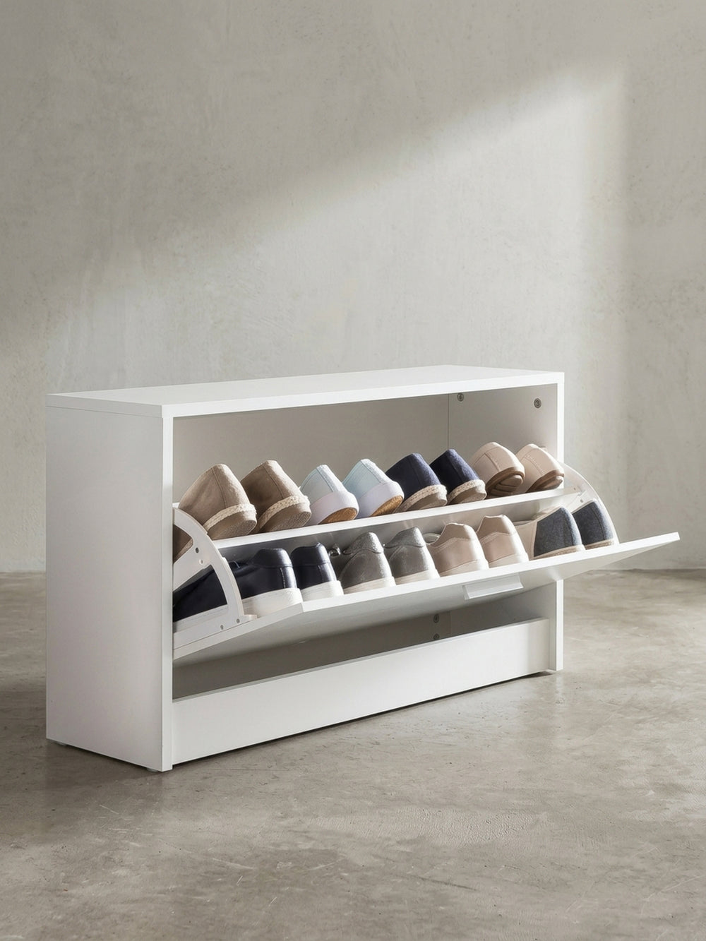 Geöffneter Schuhschrank aus beschichtetem Holzwerkstoff in Weiß mit praktischer Sitzfläche für bequemes Schuheanziehen in seitlicher Perspektive._