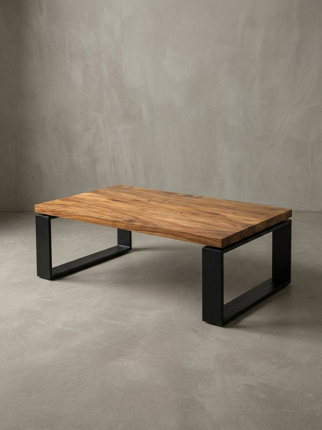 Nahaufnahme des Übergangs von Holz zu Metall. Die Kante der massiven Sheeshamholz-Platte trifft auf das robuste, matt schwarz lackierte Eisengestell des modernen Sofatisches._