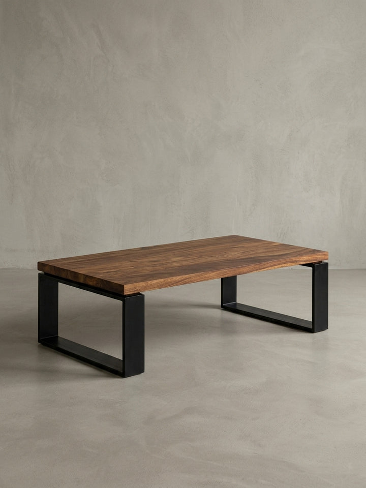 Weitere Perspektive des 115 cm breiten Wohnzimmertisches. Das naturbelassene Design der braunen Massivholzplatte harmoniert perfekt mit den geraden Linien der schwarzen Kufen._