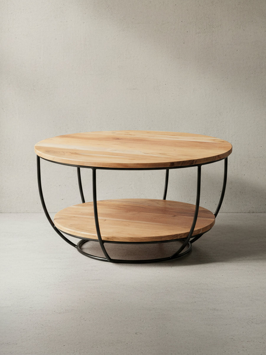 Gesamtansicht des runden Industrial-Couchtisches, der die klare Designsprache mit zwei Ebenen aus Akazienholz und einem Metallkorb-Gestell präsentiert._