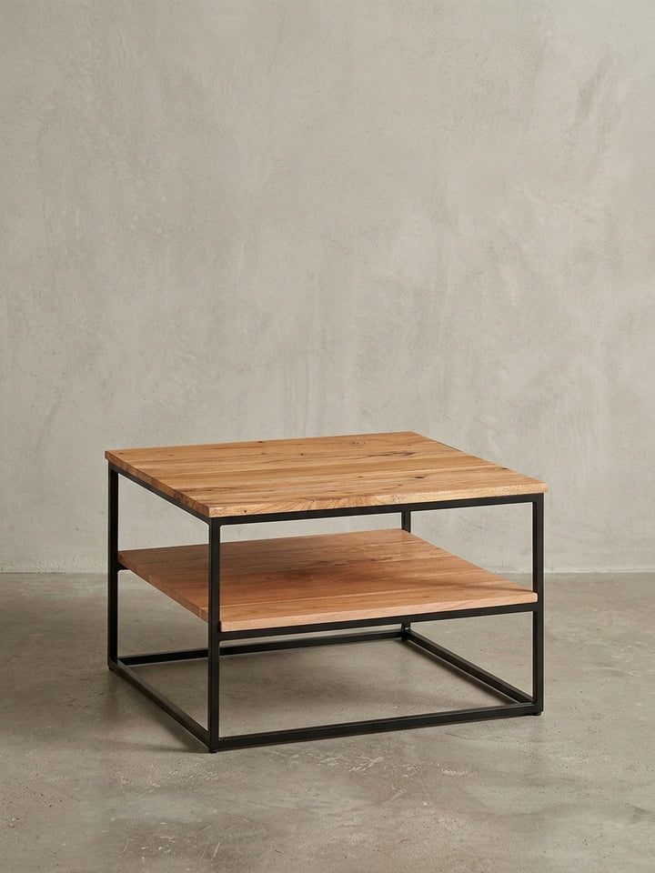 Gesamtüberblick des quadratischen Holztisches im Industrial Design, der die Kombination aus warmem Massivholz und kühlem, robustem Eisen perfekt vereint._