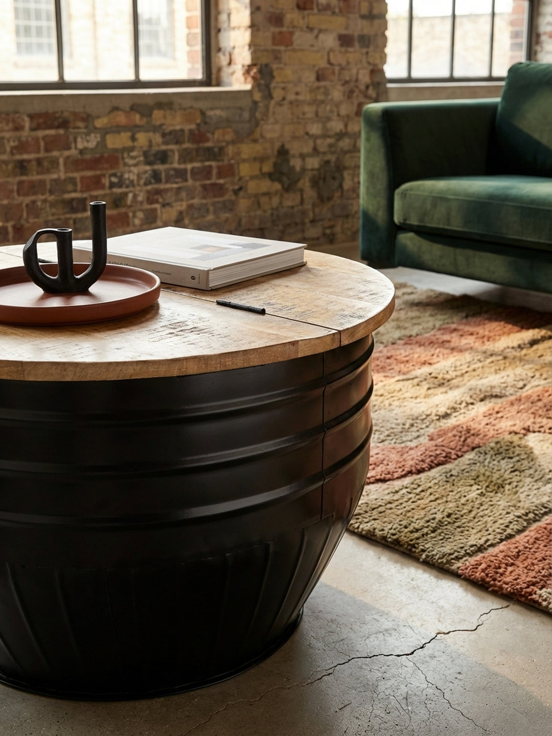 Detailaufnahme der Massivholz Tischplatte aus Mango mit sichtbarer Maserung und der robusten, mattschwarzen Metalloberfläche des Industrial Couchtischs._