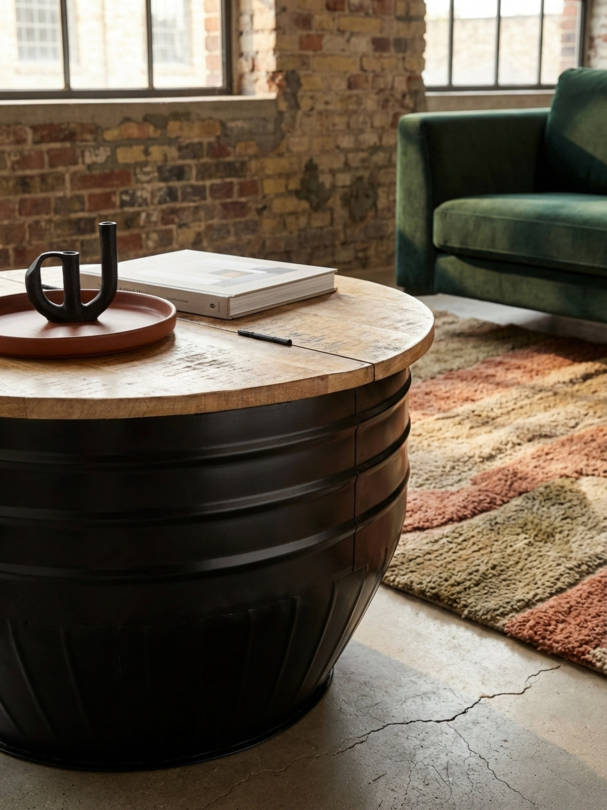 Detailaufnahme der Massivholz Tischplatte aus Mango mit sichtbarer Maserung und der robusten, mattschwarzen Metalloberfläche des Industrial Couchtischs.