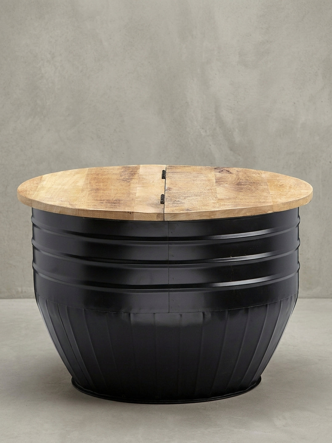 Überblick des runden Industrial Couchtischs (60x41 cm) aus massivem Mangoholz und schwarzem Eisen, ein funktionales Designmöbel mit verstecktem Stauraum._